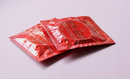 Dois preservativos fechados em embalagem vermelha.